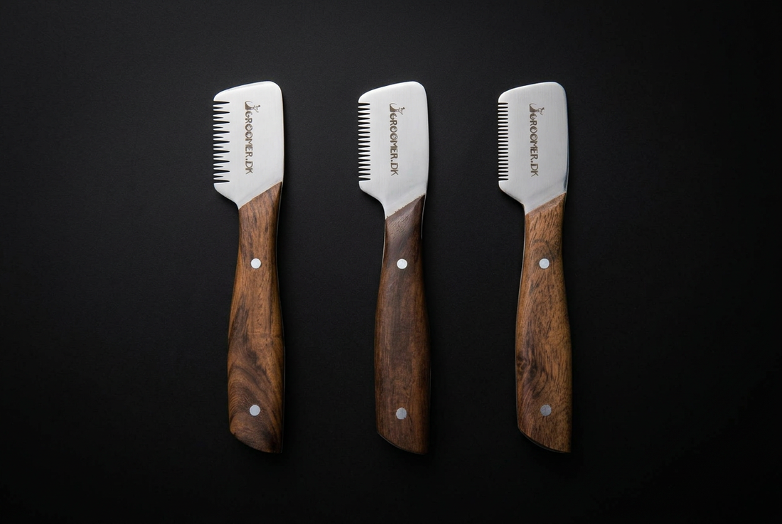 Three hand-dulled stripping knives in coarse, medium, and fine tooth widths arranged on a dark surface — GroomerDK USA